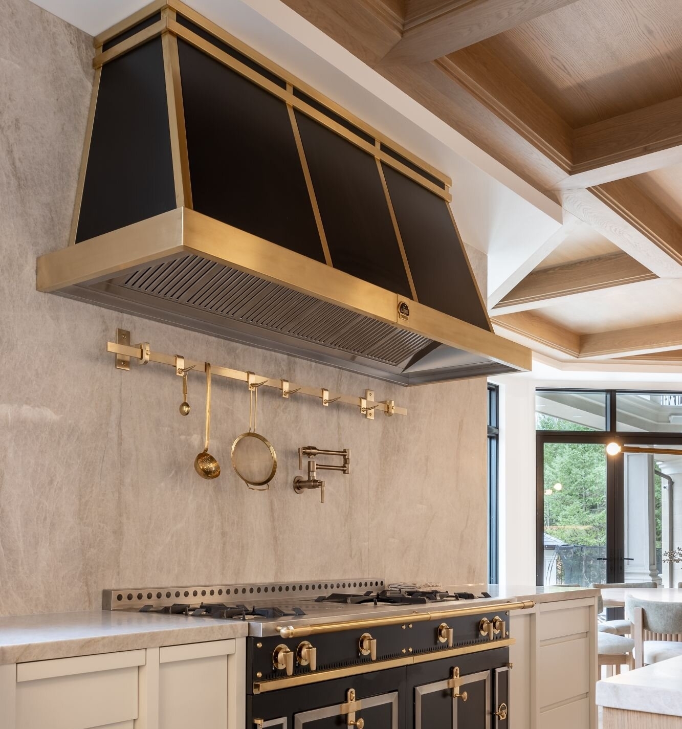 Custom wood kitchen hood with white cabinetry, handcrafted by Homestead Woodworks to match the elegant modern kitchen design
